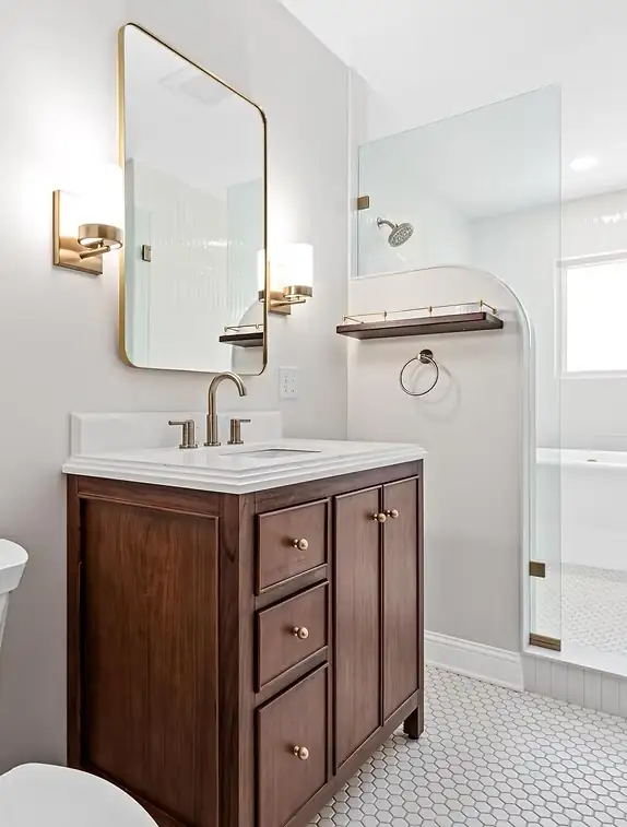Sophisticated Living bathroom in St. Paul with walnut vanity, brass sconces and a curved wall hiding the shower