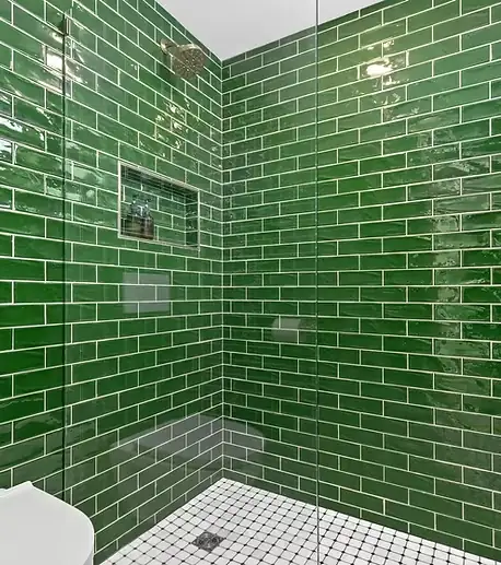 Compact wet-room shower in a St. Paul bathroom with glossy green subway tile and wall-mounted toilet