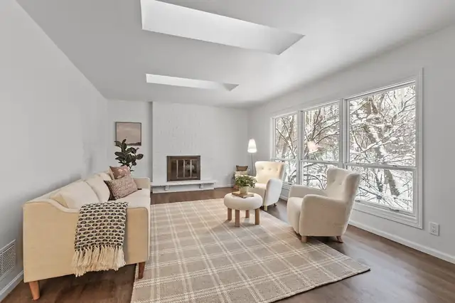 Burnsville whole-home remodel living room with skylights, white brick fireplace and wall of windows