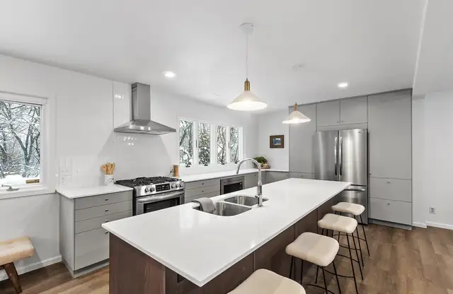 Burnsville kitchen remodel with a long white quartz island, gray cabinets and stainless appliances