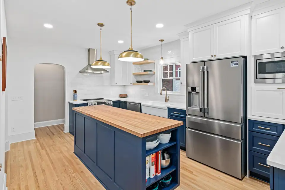 Kitchen remodeling Minneapolis area: St. Paul kitchen with navy island, butcher block top, brass pendants and white upper cabinets