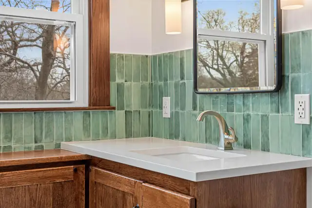Emerald Retreat bathroom in St. Paul with green zellige-style tile, white vanity top and window views